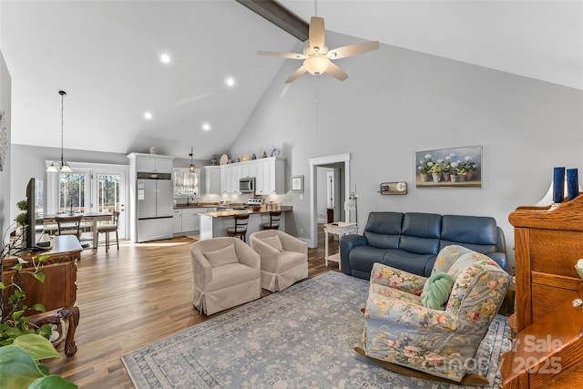 living room with a ceiling fan, light wood-style flooring, high vaulted ceiling, beam ceiling, and recessed lighting