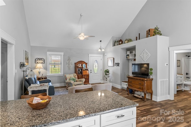 kitchen with visible vents, dark stone counters, dark wood-style floors, high vaulted ceiling, and white cabinetry