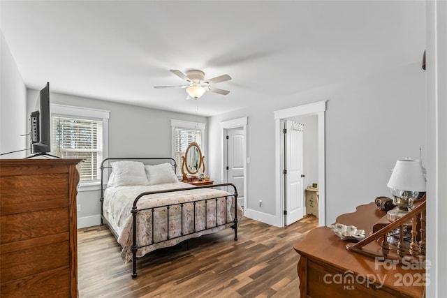 bedroom featuring dark wood finished floors, a ceiling fan, and baseboards