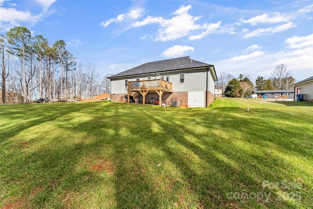 rear view of property featuring brick siding, a wooden deck, and a yard