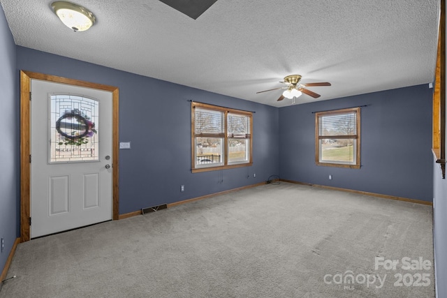 interior space featuring plenty of natural light, visible vents, ceiling fan, and baseboards