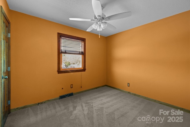 spare room featuring a textured ceiling, ceiling fan, carpet flooring, visible vents, and baseboards