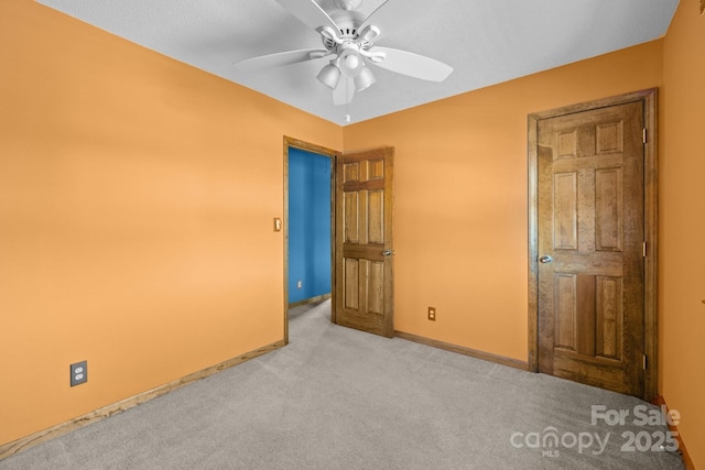 unfurnished bedroom featuring carpet, baseboards, and ceiling fan