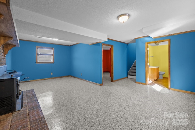 interior space with ensuite bath, a textured ceiling, baseboards, and speckled floor