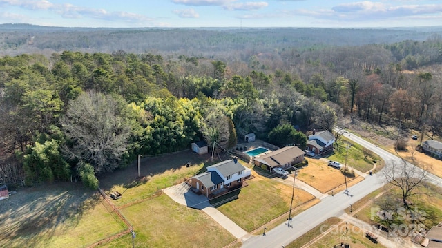 drone / aerial view featuring a wooded view