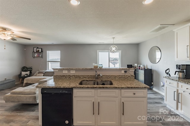 kitchen with a sink, white cabinets, black dishwasher, open floor plan, and an island with sink