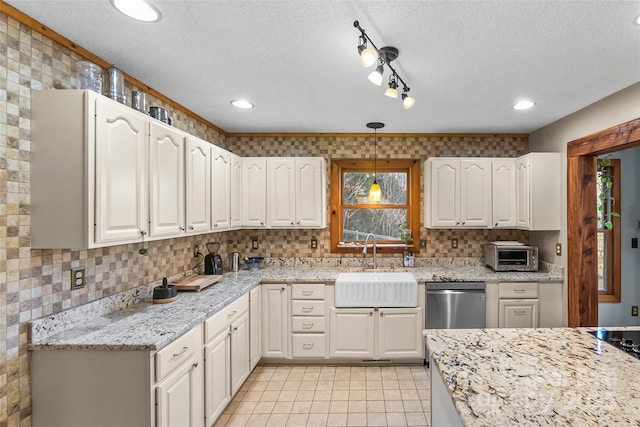 kitchen with a sink, decorative light fixtures, tasteful backsplash, stainless steel dishwasher, and light stone countertops