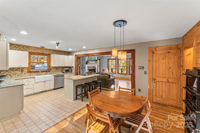 dining room with a toaster, recessed lighting, and light wood finished floors