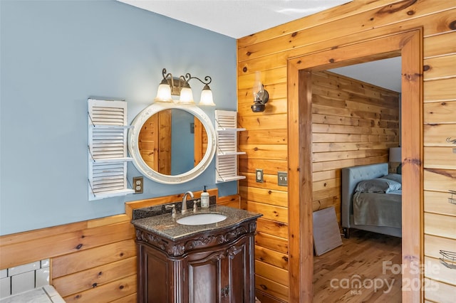 bathroom featuring wood finished floors, wood walls, and vanity