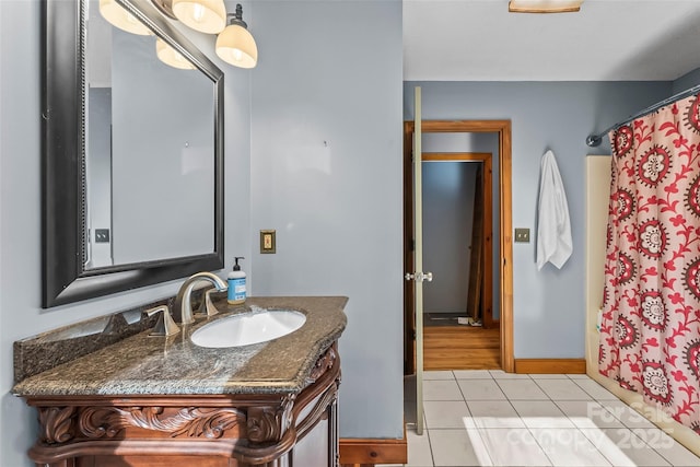 bathroom with tile patterned floors, baseboards, and vanity