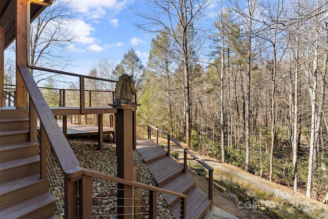 deck with stairway and a wooded view