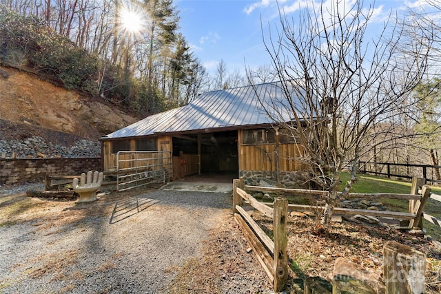 view of outbuilding featuring an exterior structure, a carport, an outdoor structure, and driveway