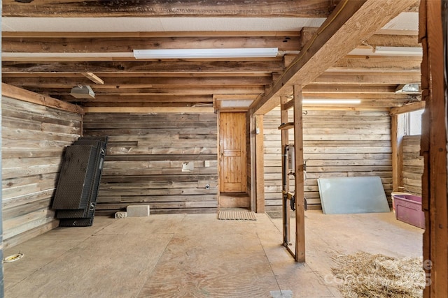 unfurnished living room featuring wood walls