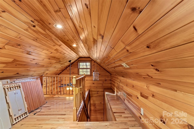 bonus room with a sauna, light wood-style floors, wooden walls, wooden ceiling, and lofted ceiling