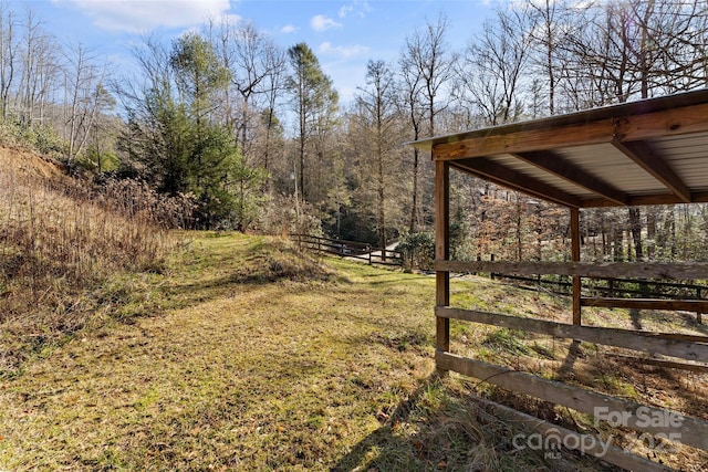 view of yard with a view of trees and fence