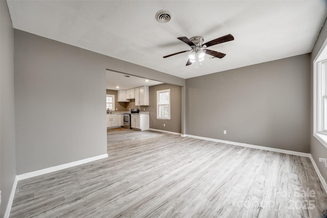 unfurnished living room featuring light wood-style flooring and baseboards