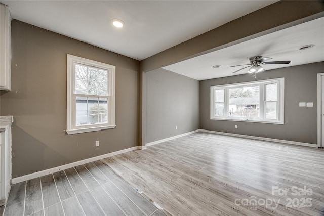 unfurnished room featuring light wood-type flooring, visible vents, baseboards, and ceiling fan