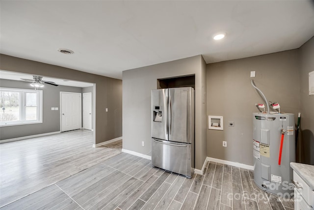 kitchen with water heater, baseboards, stainless steel fridge, and wood tiled floor