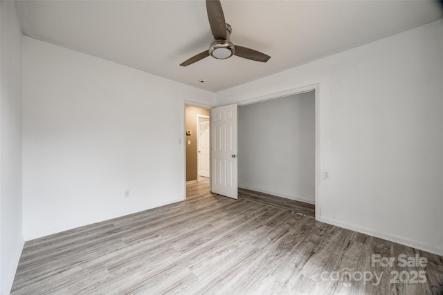 unfurnished bedroom with a ceiling fan, a closet, baseboards, and wood finished floors