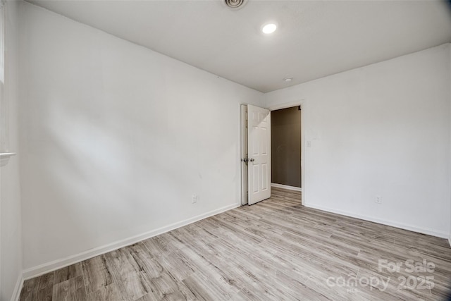 unfurnished room featuring baseboards and wood finished floors