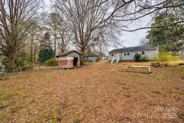 view of yard featuring an outbuilding, fence, and a shed