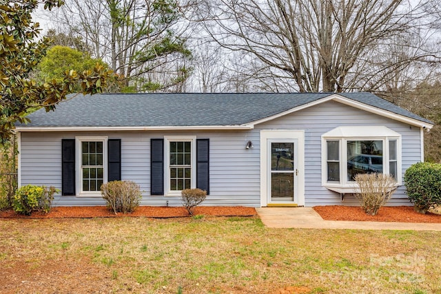 ranch-style home with a front lawn and a shingled roof