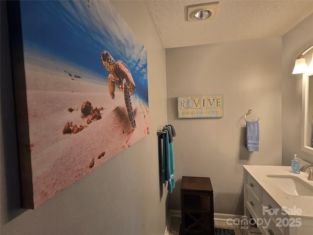 bathroom featuring a textured ceiling and vanity