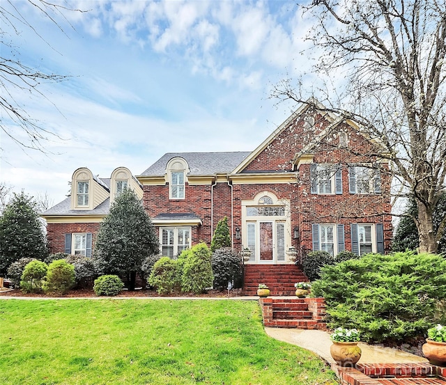 view of front facade with a front yard and brick siding