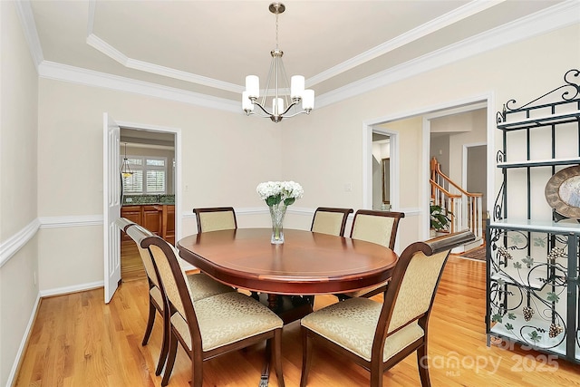 dining area with light wood finished floors, a notable chandelier, stairs, and baseboards