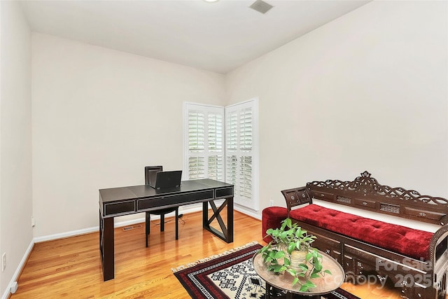 office area with visible vents, baseboards, and wood finished floors