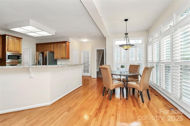 dining area featuring light wood-type flooring and a wealth of natural light