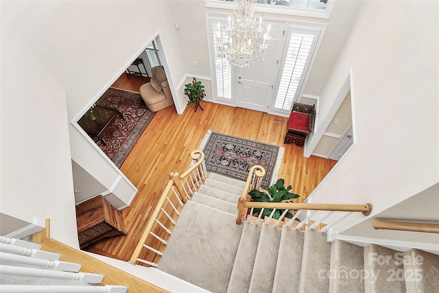 foyer featuring a notable chandelier, stairs, and wood finished floors