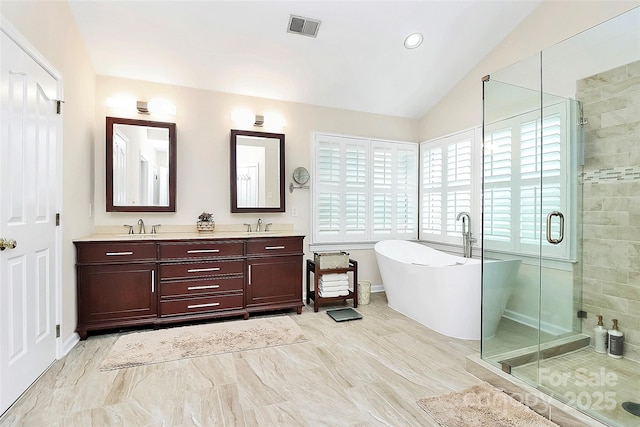 bathroom with a freestanding bath, vaulted ceiling, a stall shower, and a sink