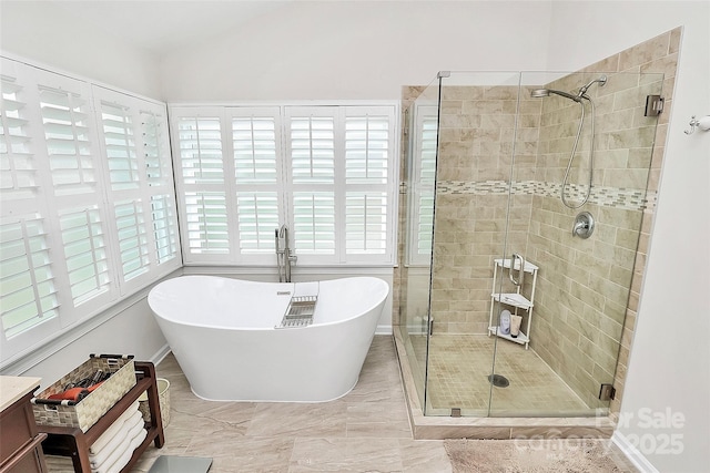 full bathroom featuring a shower stall, vaulted ceiling, a wealth of natural light, and a freestanding bath