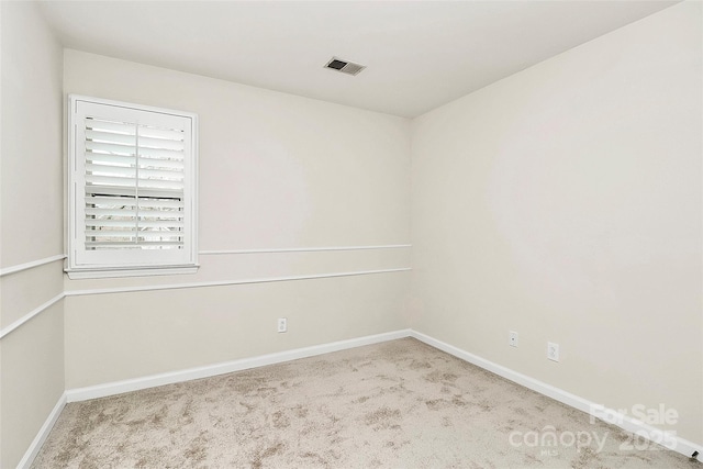 carpeted empty room featuring visible vents and baseboards