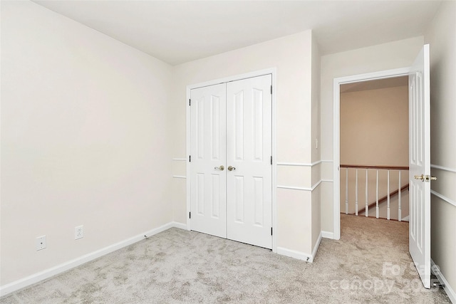 unfurnished bedroom with a closet, baseboards, and carpet floors