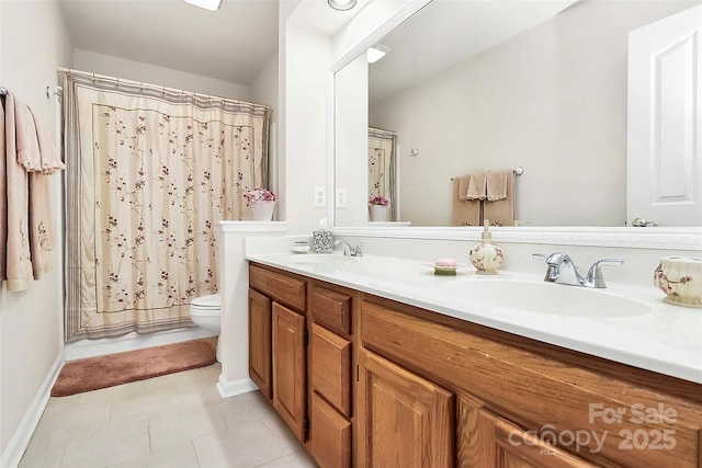 bathroom with tile patterned floors, double vanity, toilet, and a sink