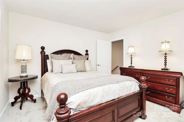 bedroom with baseboards and light carpet