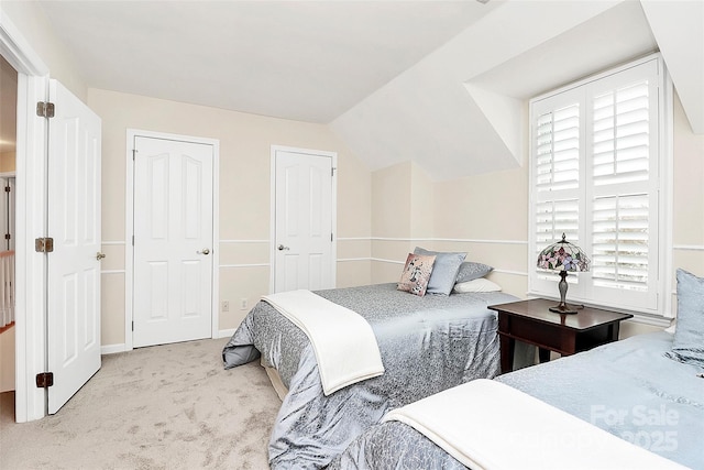 bedroom with carpet floors and vaulted ceiling