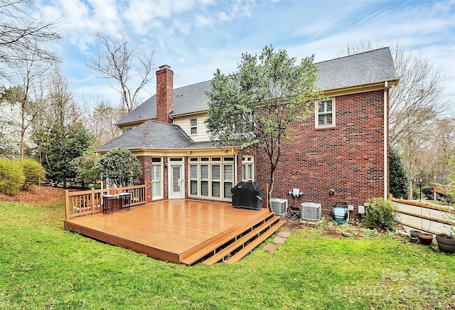 back of house with a wooden deck, a yard, brick siding, and a chimney