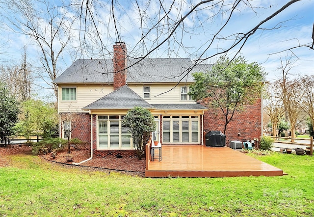 back of house featuring brick siding, central air condition unit, a lawn, a chimney, and a deck