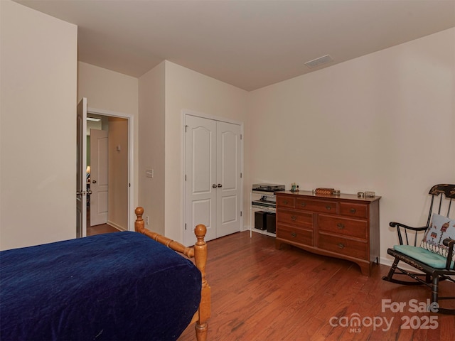 bedroom featuring wood finished floors and visible vents