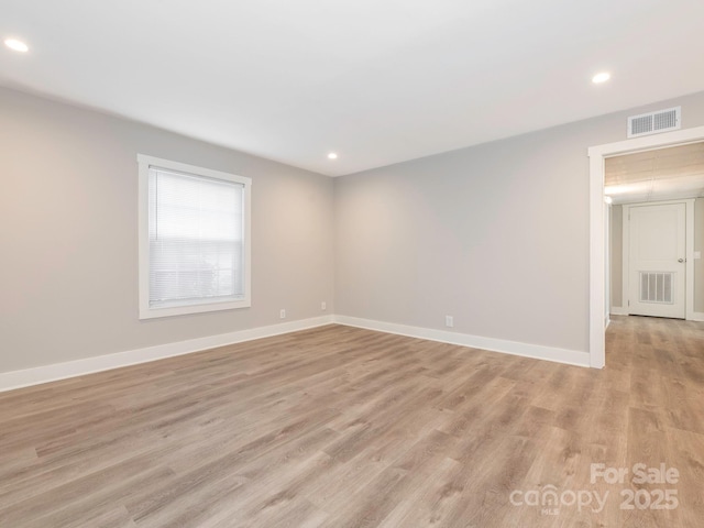 empty room with light wood-style floors, baseboards, visible vents, and recessed lighting