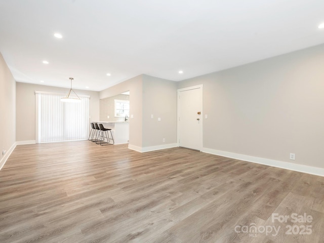 unfurnished living room featuring light wood-style floors, recessed lighting, and baseboards