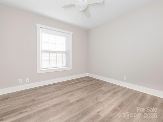 spare room featuring ceiling fan, baseboards, and wood finished floors