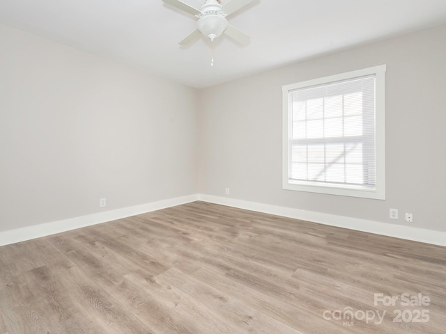 unfurnished room featuring ceiling fan, wood finished floors, and baseboards