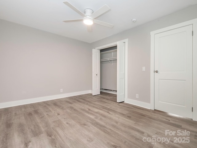 unfurnished bedroom featuring ceiling fan, a closet, light wood-type flooring, and baseboards