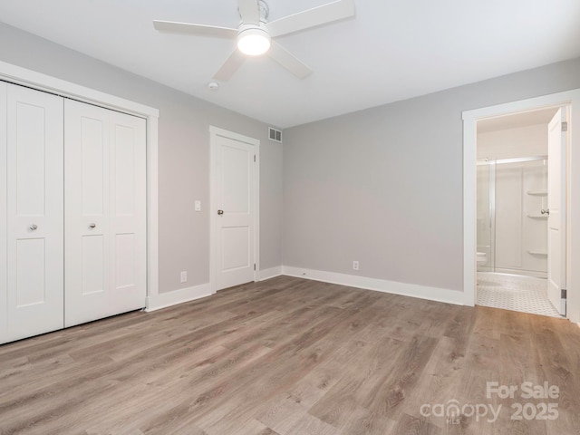 unfurnished bedroom with a closet, baseboards, and wood finished floors