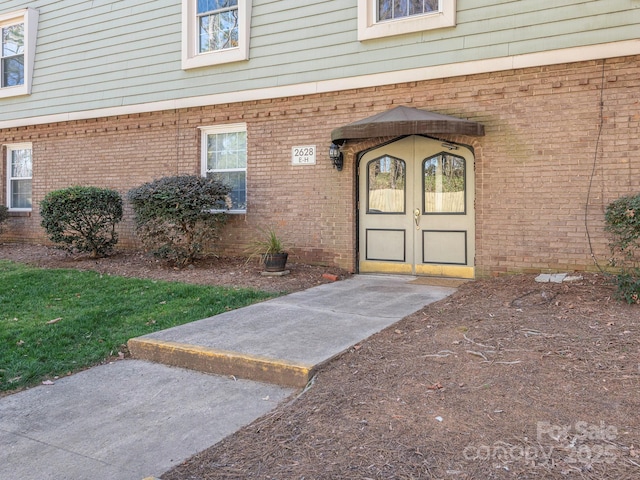 entrance to property featuring brick siding