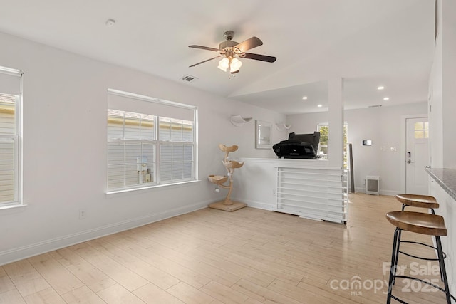 interior space with visible vents, baseboards, light wood-style flooring, vaulted ceiling, and recessed lighting